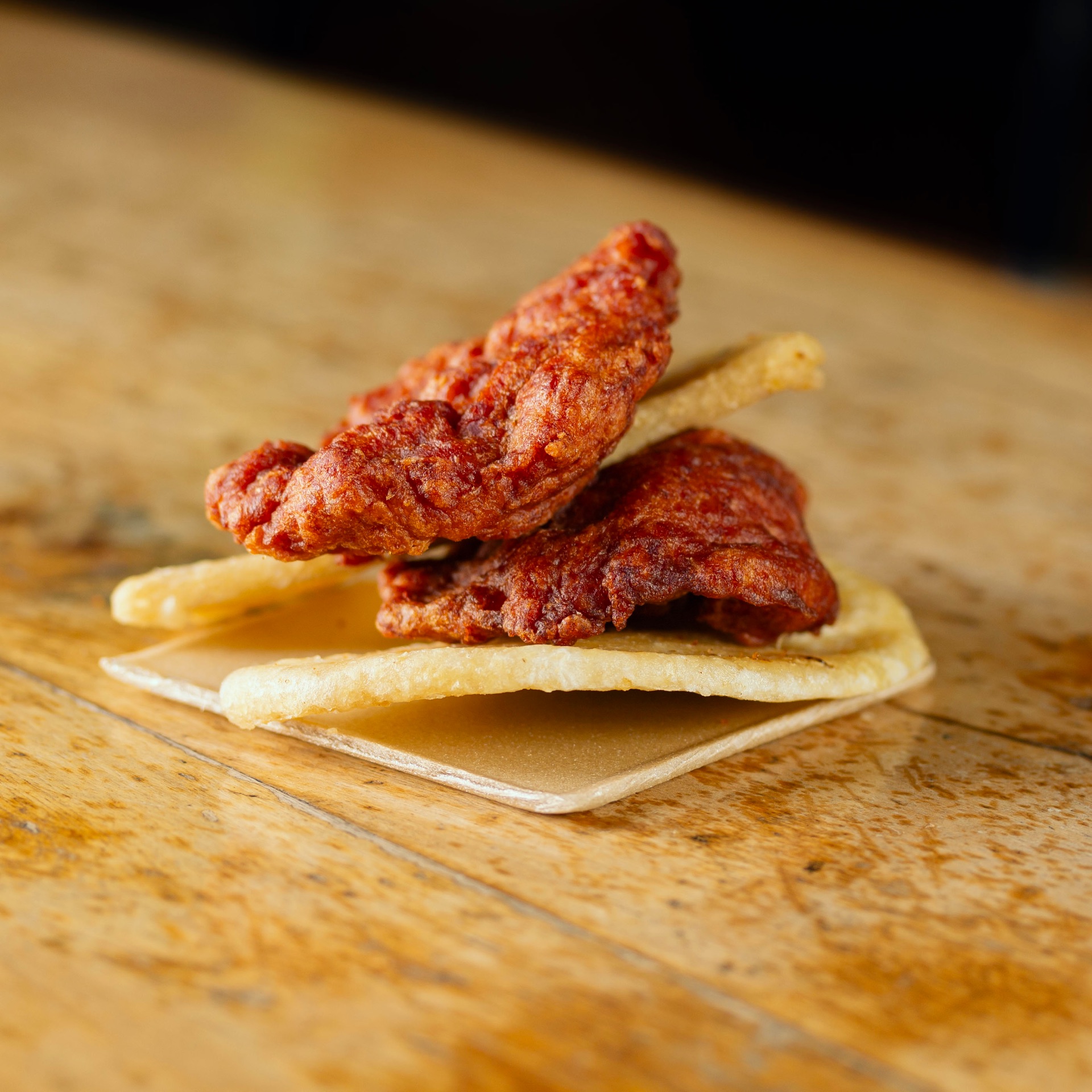 Bombones de pollo apanados sobre arepa